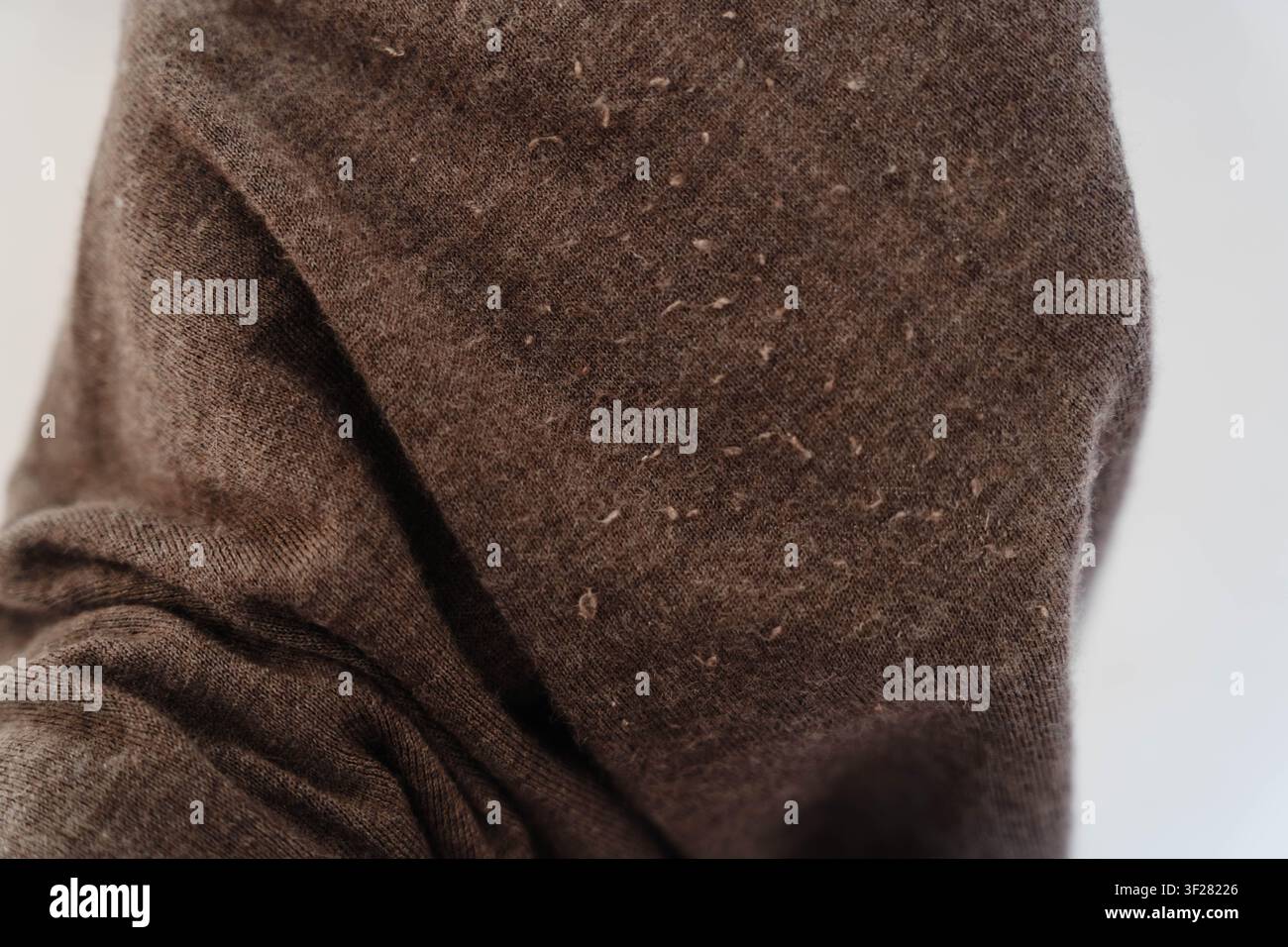 Primo piano del pilling su tessuto di cashmere. Cura dell'abbigliamento, manutenzione del tessuto e prolungamento della durata di vita dei capi attraverso una corretta cura tessile Foto Stock