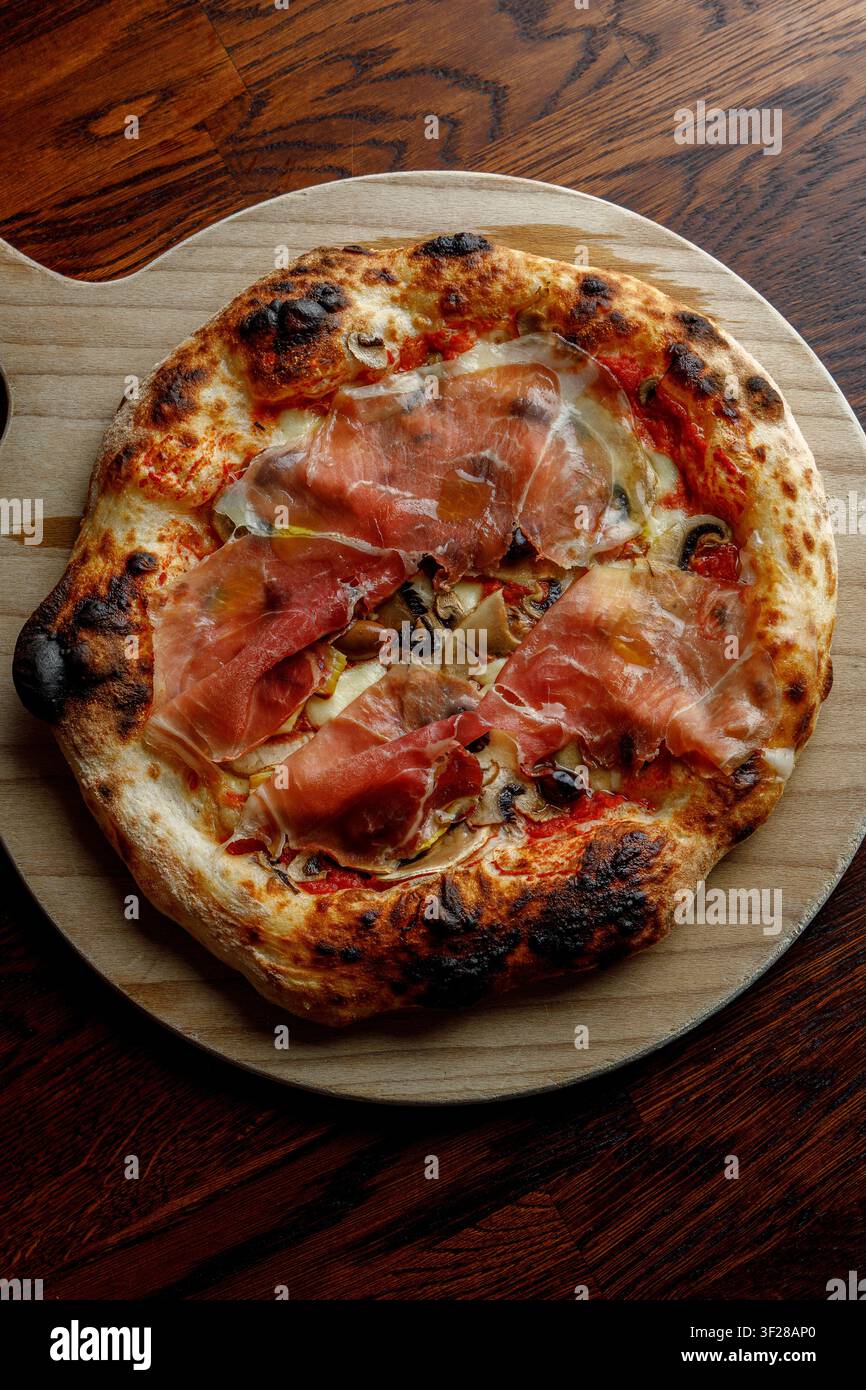Pizza artigianale con prosciutto, olive e funghi. Foto Stock