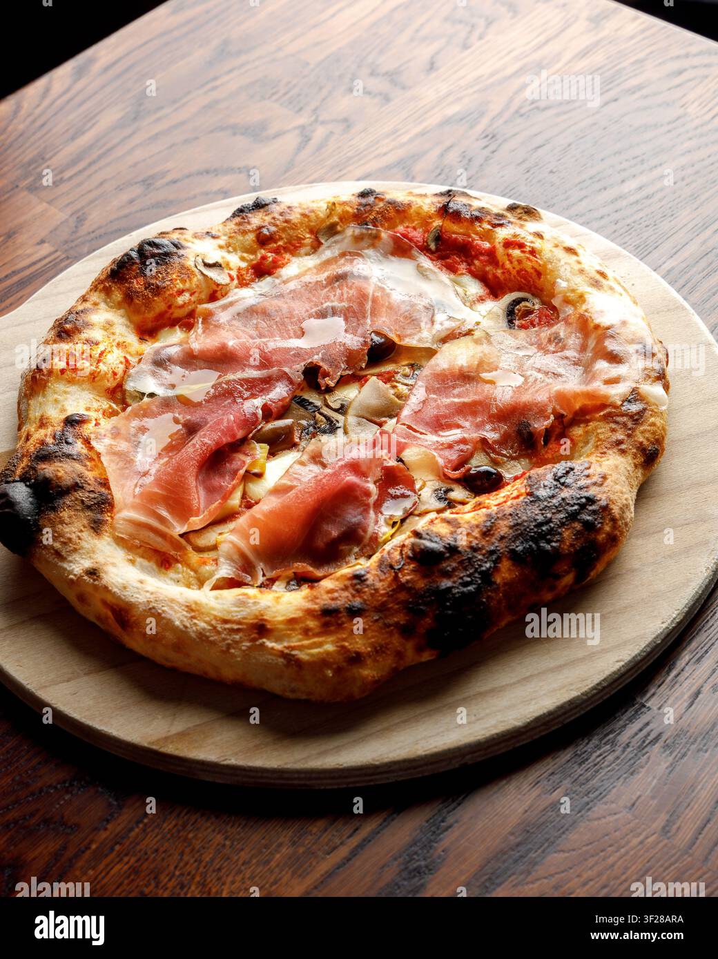 Pizza artigianale con prosciutto, olive e funghi. Foto Stock