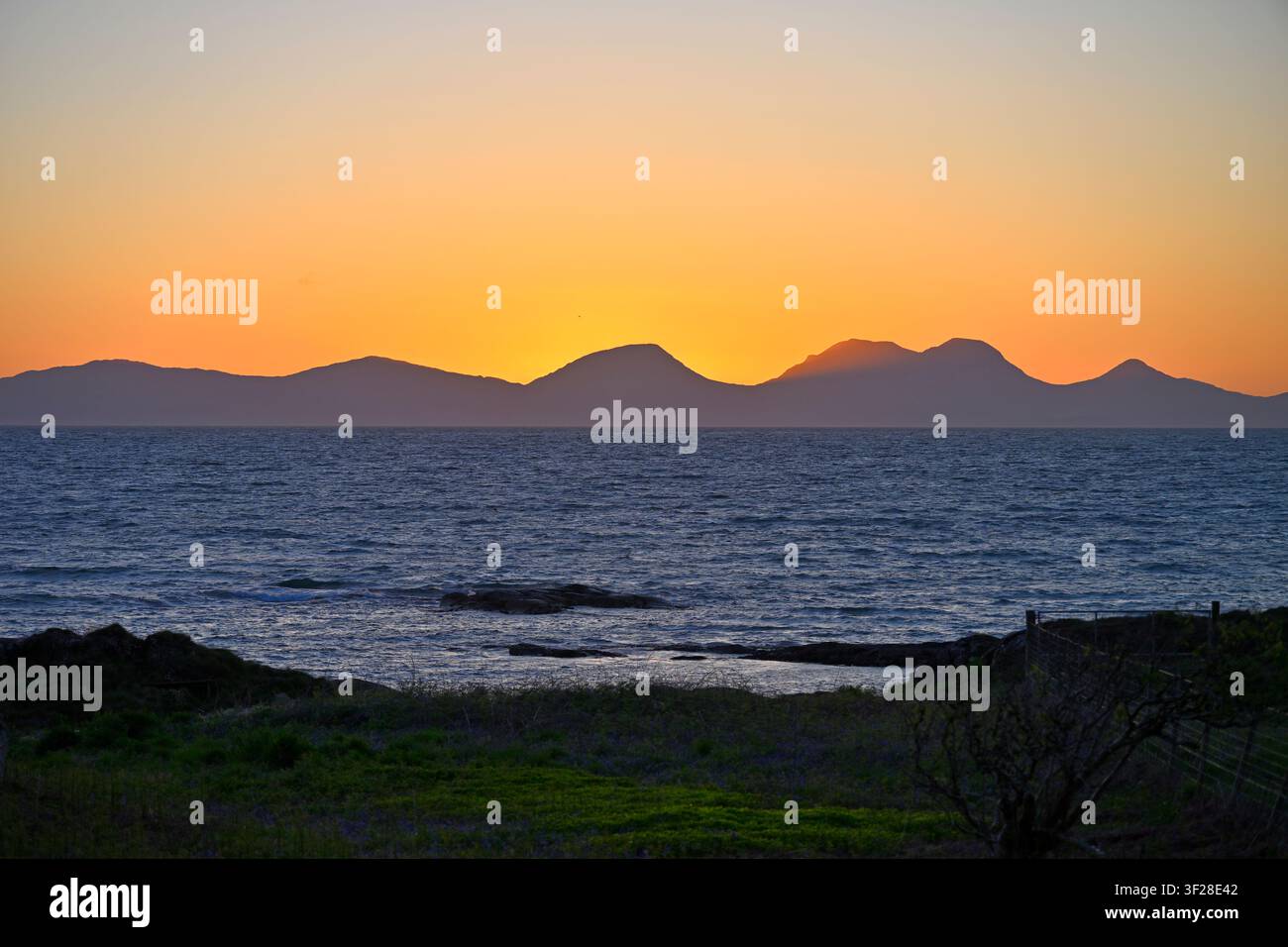Tramonto sulle montagne dell'Isle of Jura, o Paps of Jura, visto dalla terraferma, Scozia UK maggio Foto Stock