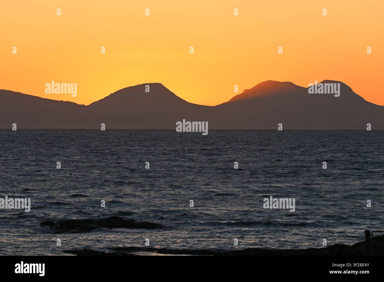 Tramonto sulle montagne dell'Isle of Jura, o Paps of Jura, visto dalla terraferma, Scozia UK maggio Foto Stock