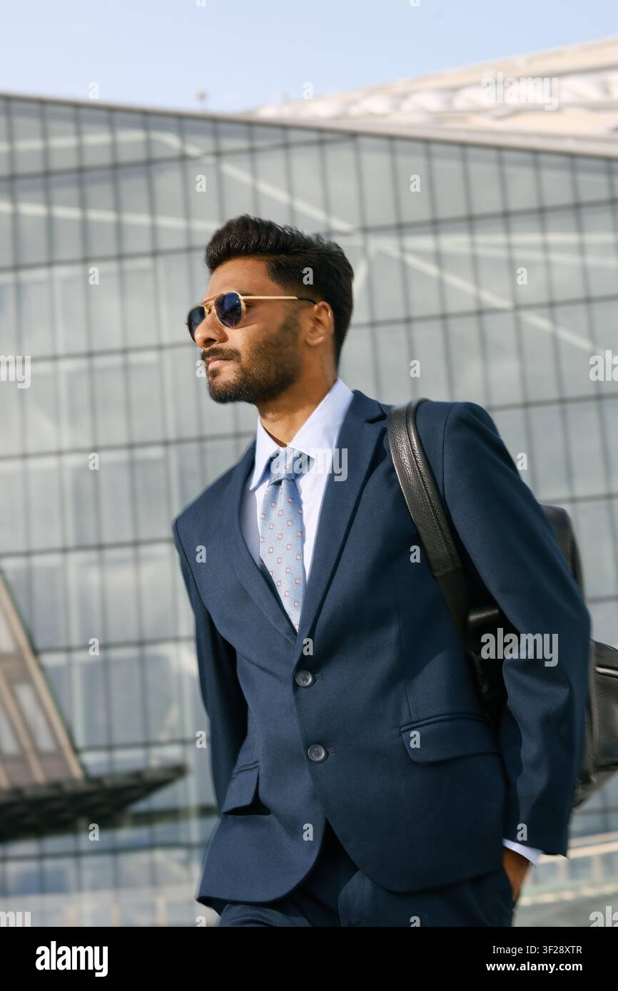 Uomo d'affari indiano adulto che cammina fuori dall'ufficio aziendale Foto Stock