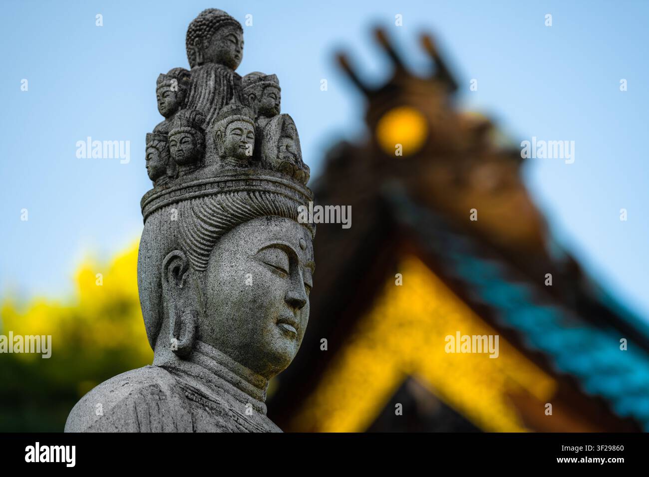 Una statua in pietra di Jūichimen Kannon (Kannon a undici teste) si trova davanti al tempio Daisho-in sull'isola di Miyajima, in Giappone. Foto Stock