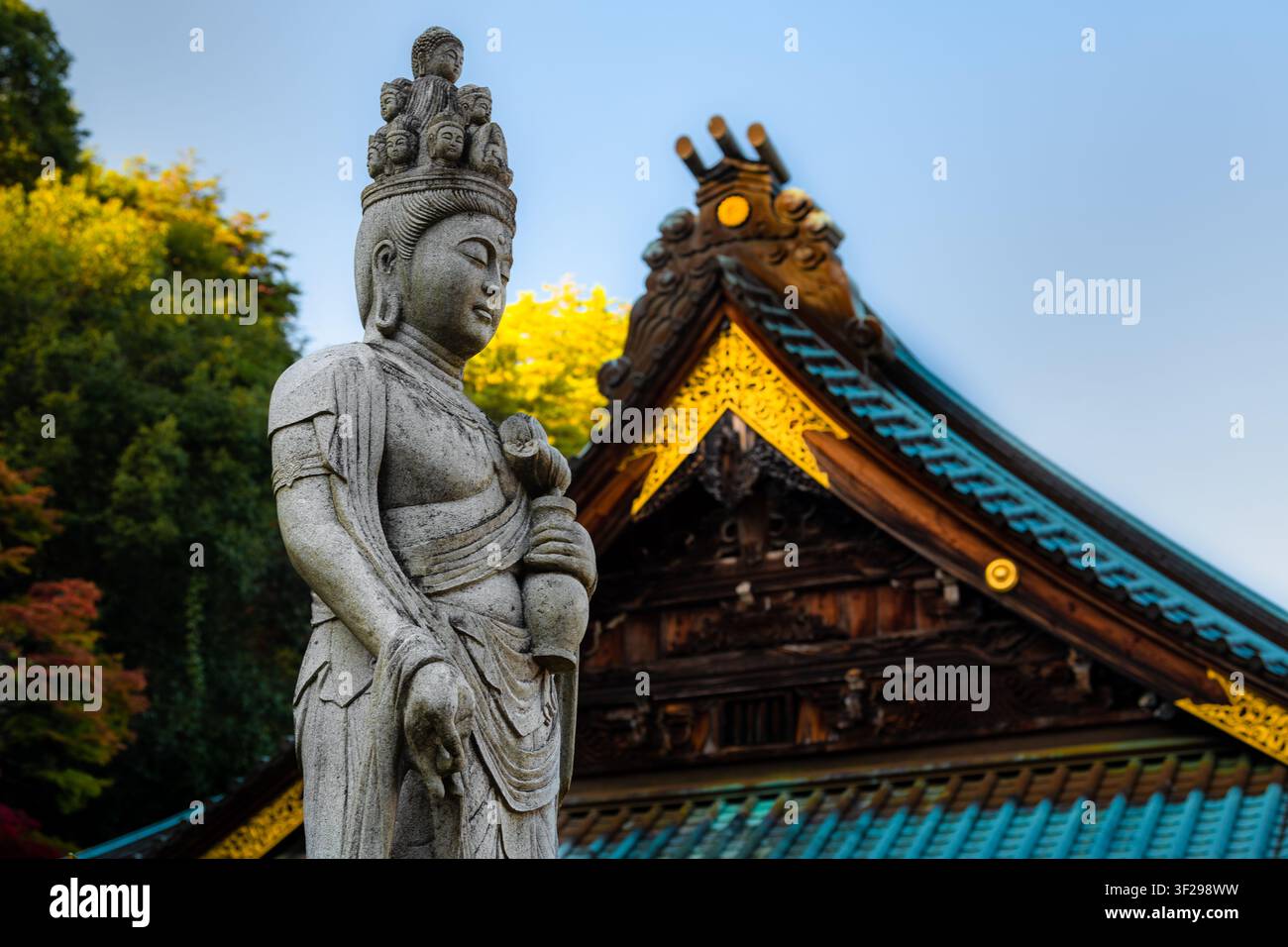 Una statua in pietra di Jūichimen Kannon (Kannon a undici teste) si trova davanti al tempio Daisho-in sull'isola di Miyajima, in Giappone. Foto Stock