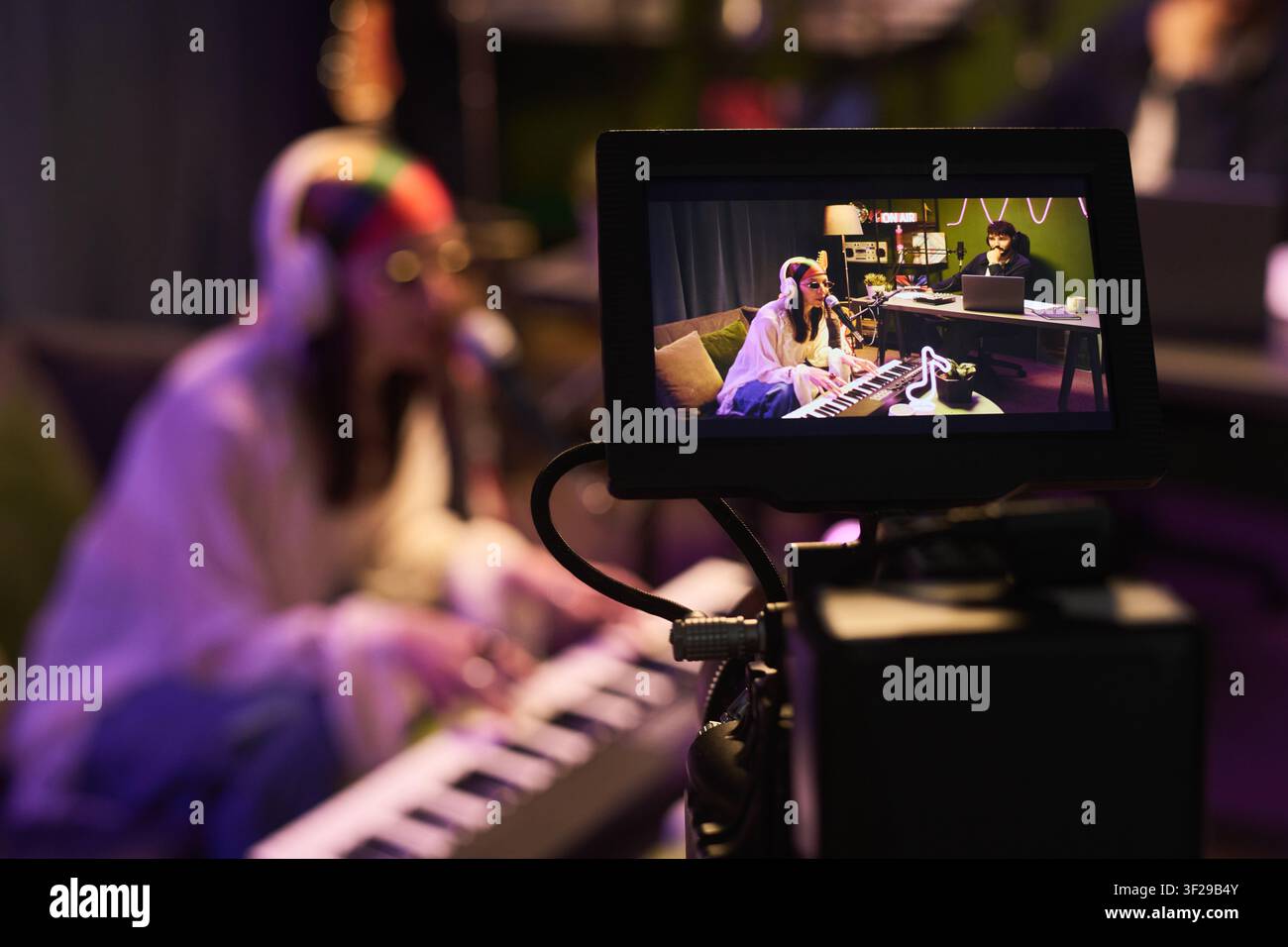 Donna che trasmette in streaming una performance musicale per la creazione di contenuti online Foto Stock