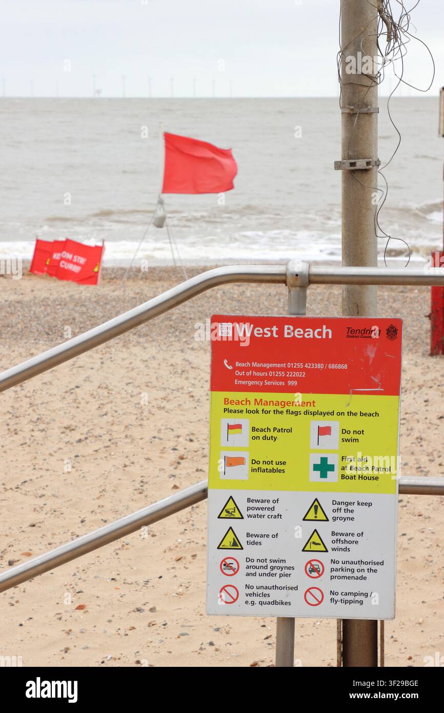 Segnale di gestione della spiaggia e bandiera rossa, che significa "Non nuotare", sulla spiaggia di Clacton on Sea, Essex, Regno Unito Foto Stock