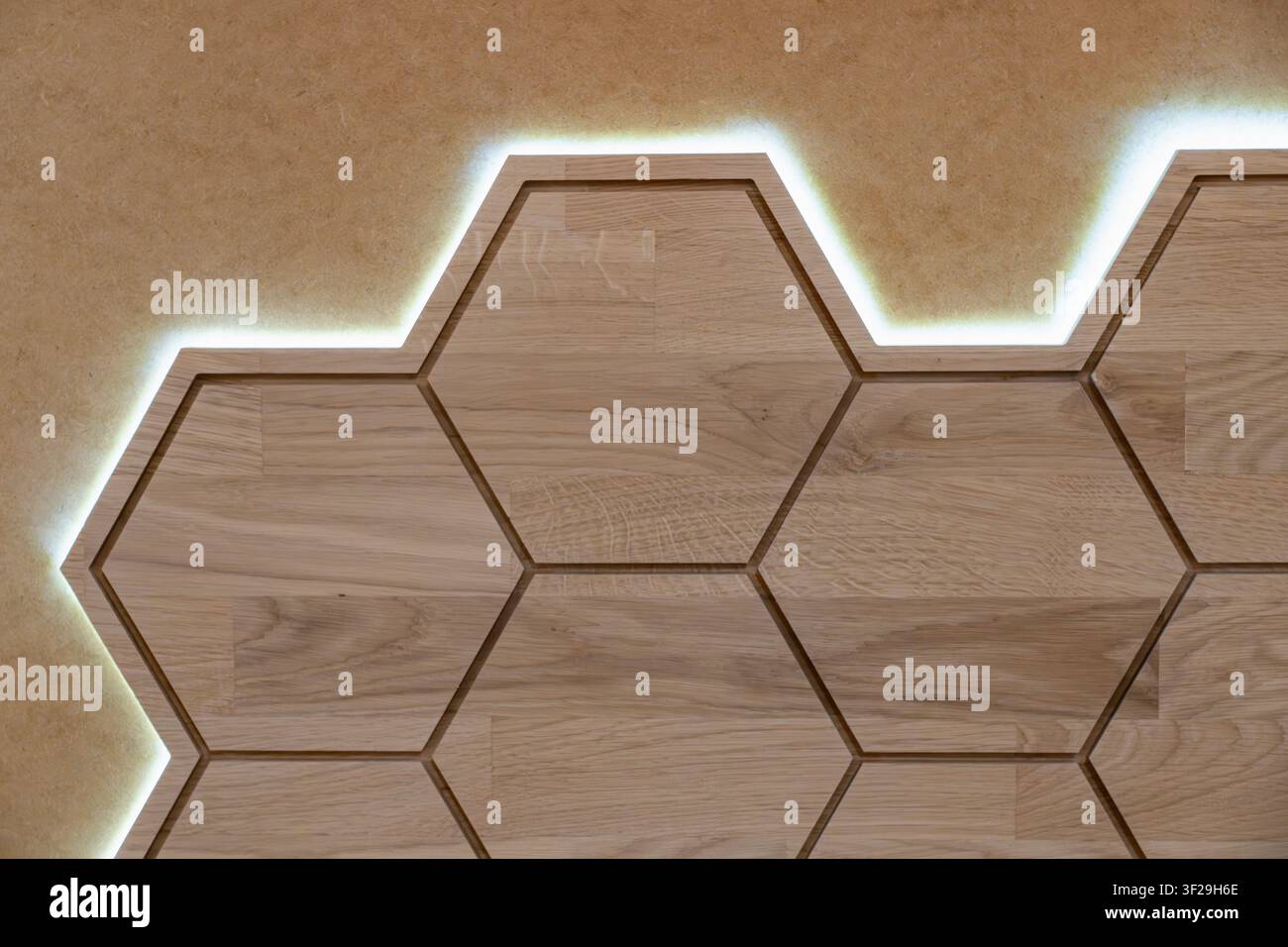 Pannello murale esagonale in legno con retroilluminazione a LED, design a nido d'ape illuminato per pareti moderne Foto Stock