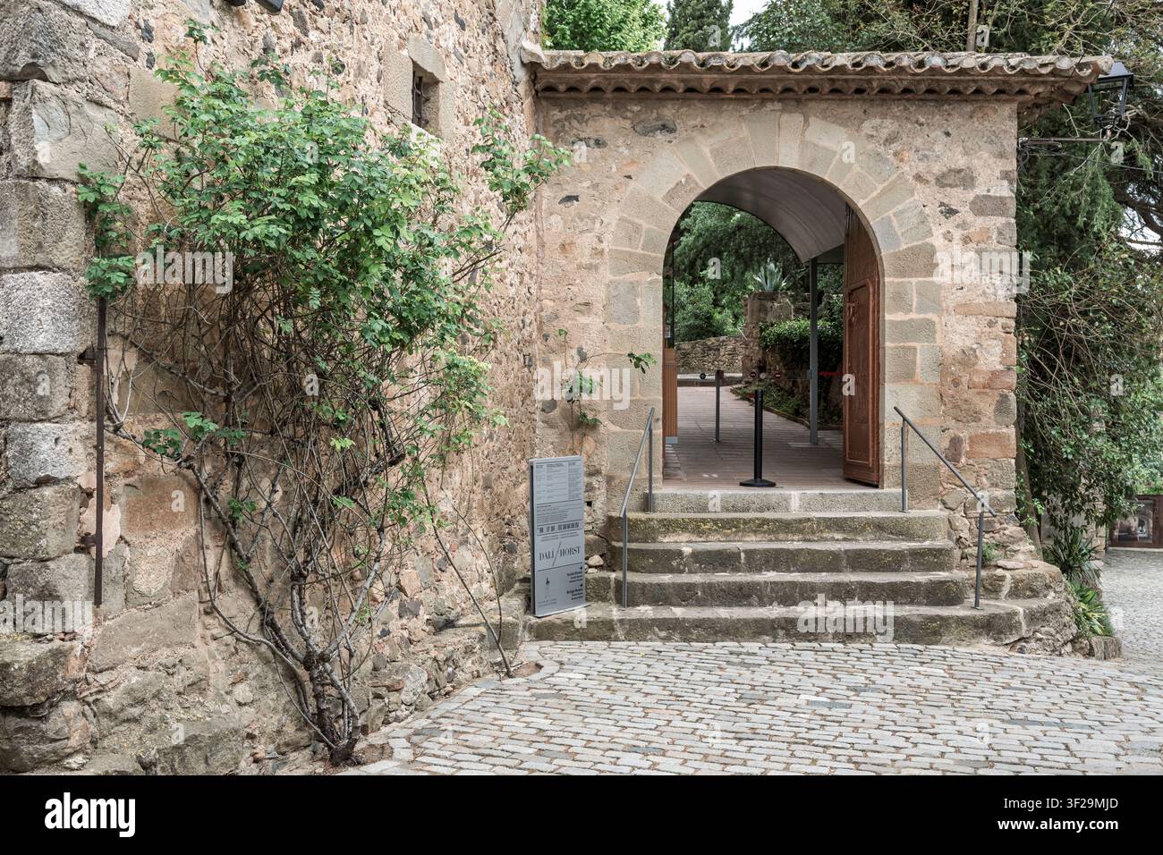 Ingresso in pietra e arco del castello Gala Dalí a Púbol, Girona, Catalogna, Catalunya, Spagna. Comprende muratura antica, scale e segnaletica del museo. Foto Stock