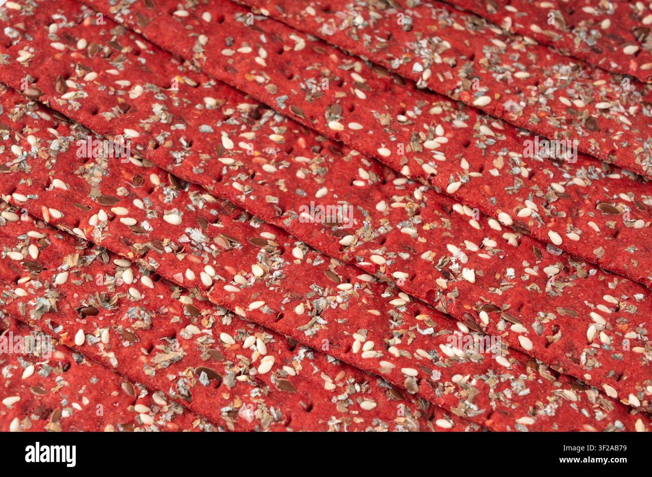 Sfondo a trama di cracker alla barbabietola, motivo di pane rusk sottile alla barbabietola, banner di pane integrale croccante rosso dietetico, vari semi pane integrale croccante Foto Stock