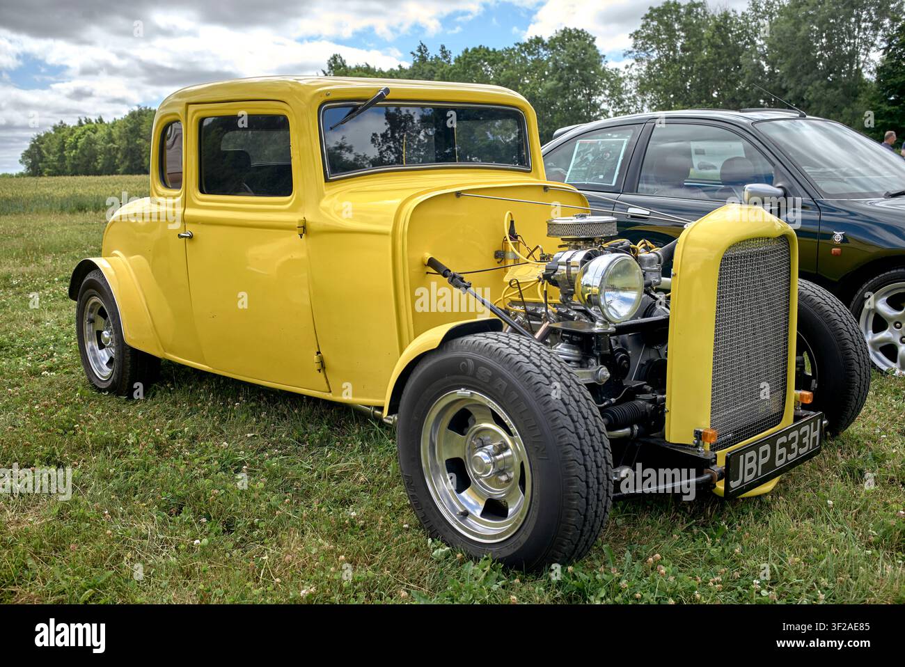 Veicolo Hot Rod Ford coupé del 1932, giallo. Fortemente modificato, con motore e sospensioni esposti, ispirato all'auto del film "American Graffiti". Foto Stock