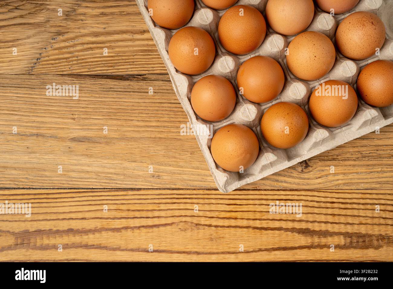 Portauova su sfondo rustico di legno, confezione da venti uova marroni, 20 uova biologiche fresche in contenitore di carta Foto Stock