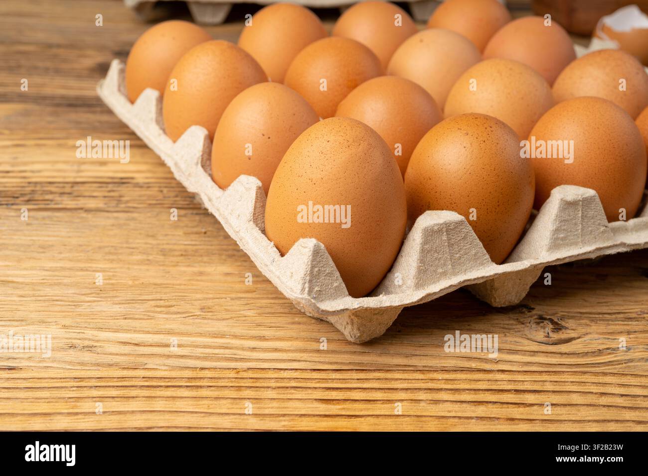 Portauova su sfondo rustico di legno, confezione da venti uova marroni, 20 uova biologiche fresche in contenitore di carta Foto Stock