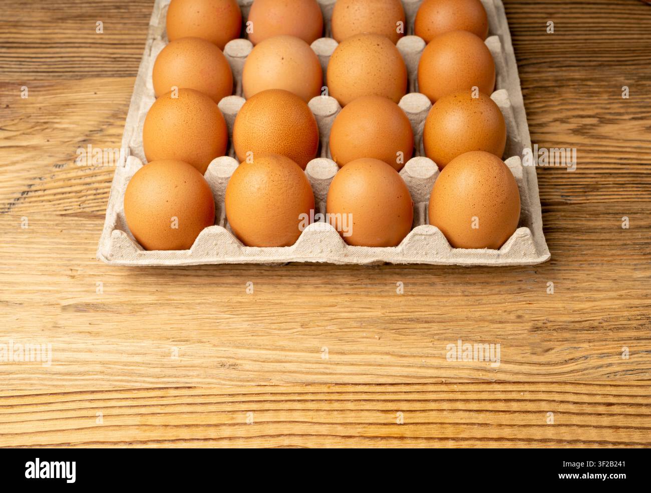 Portauova su sfondo rustico di legno, confezione da venti uova marroni, 20 uova biologiche fresche in contenitore di carta Foto Stock