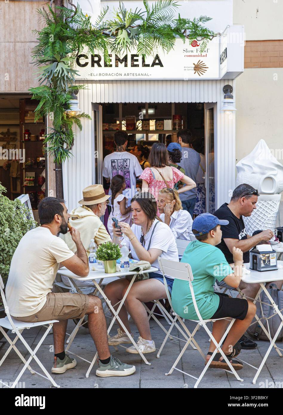 Le persone si godono un gelato nel villaggio di Llanes, principato delle Asturie, Spagna Foto Stock