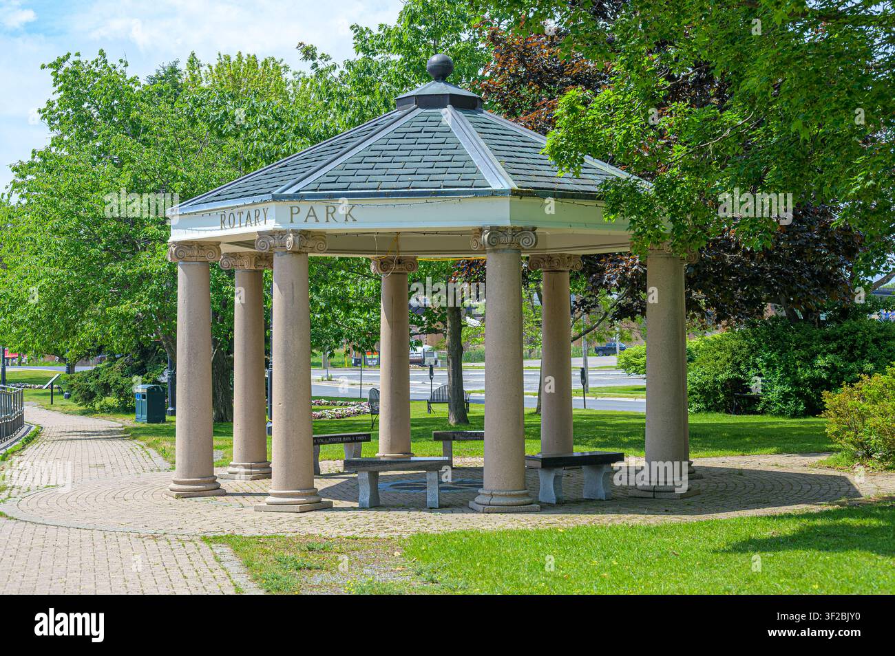 Padiglione del Rotary Park con colonne classiche, panchine e paesaggio verde circostante Foto Stock