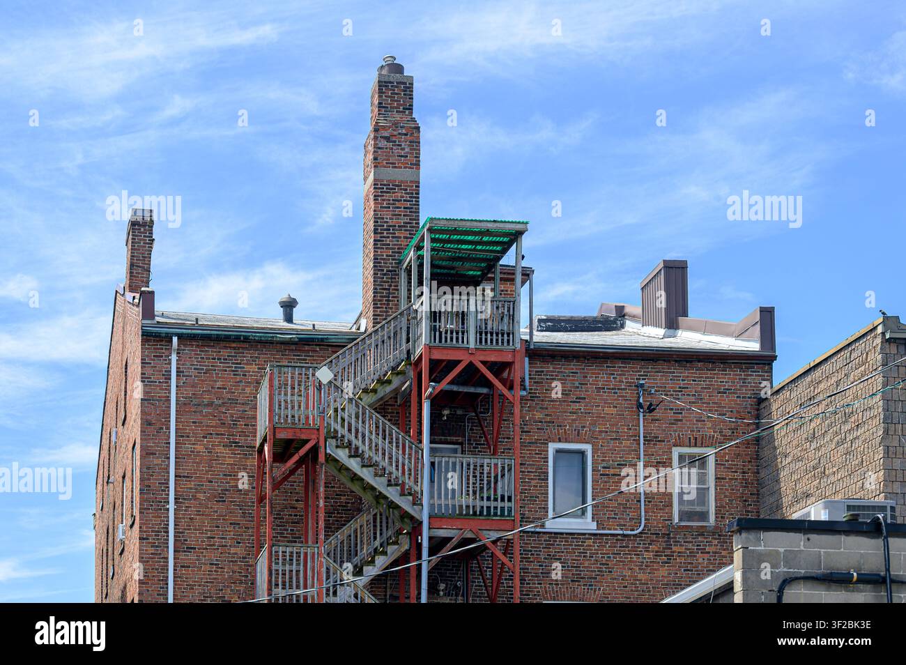 Edificio in mattoni in stile coloniale con scala di fuga esterna Foto Stock