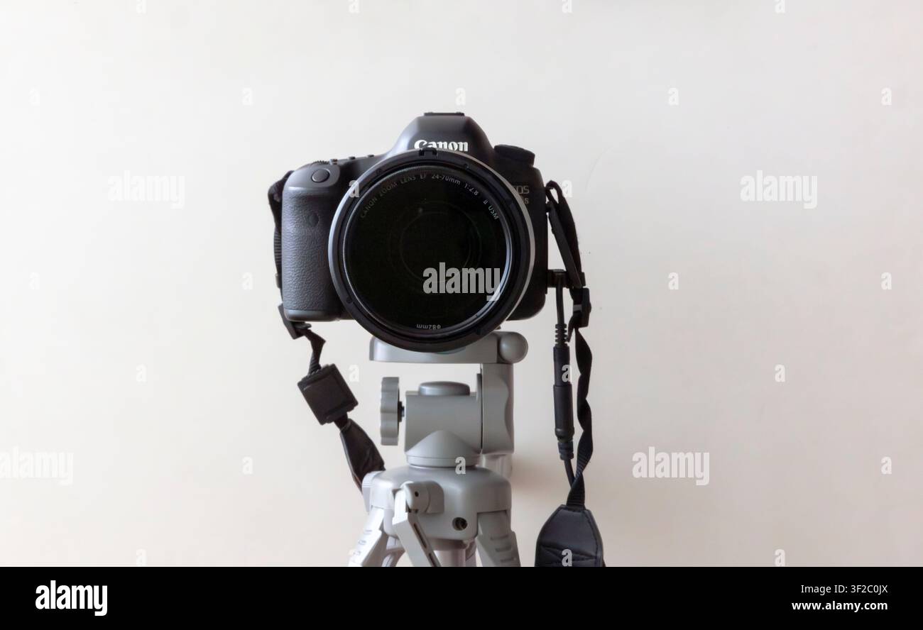 Vista frontale di una fotocamera Canon DSLR montata su un treppiede isolata su sfondo bianco Foto Stock