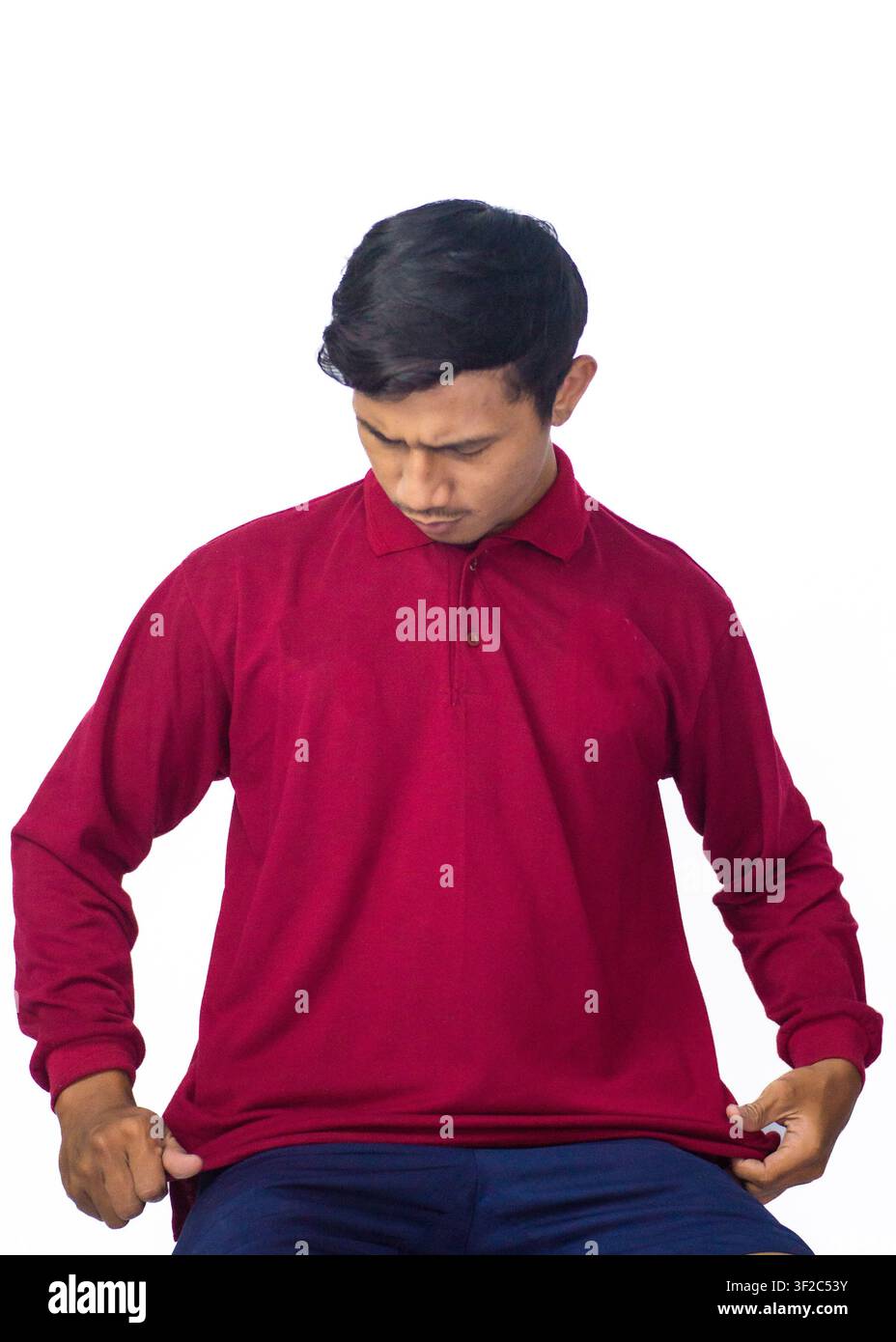 Ritratto di un uomo asiatico elegante con camicia tradizionale rossa e berretto piatto, che posa casualmente su sfondo bianco. Foto Stock