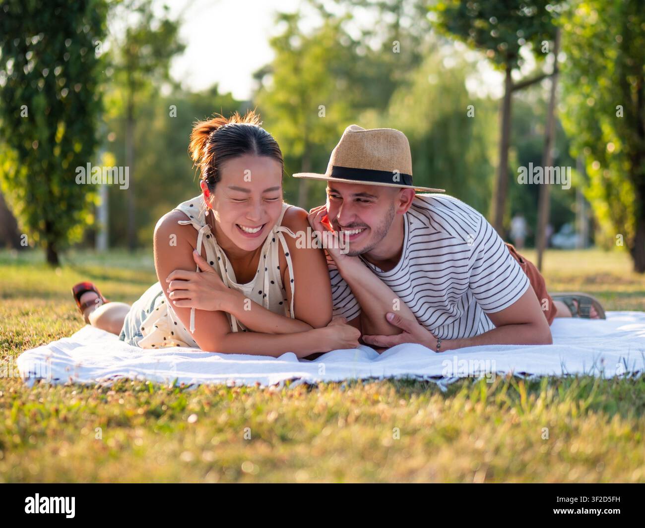 Coppia multirazziale allegra sorride e si diverte nel parco in estate. Foto Stock