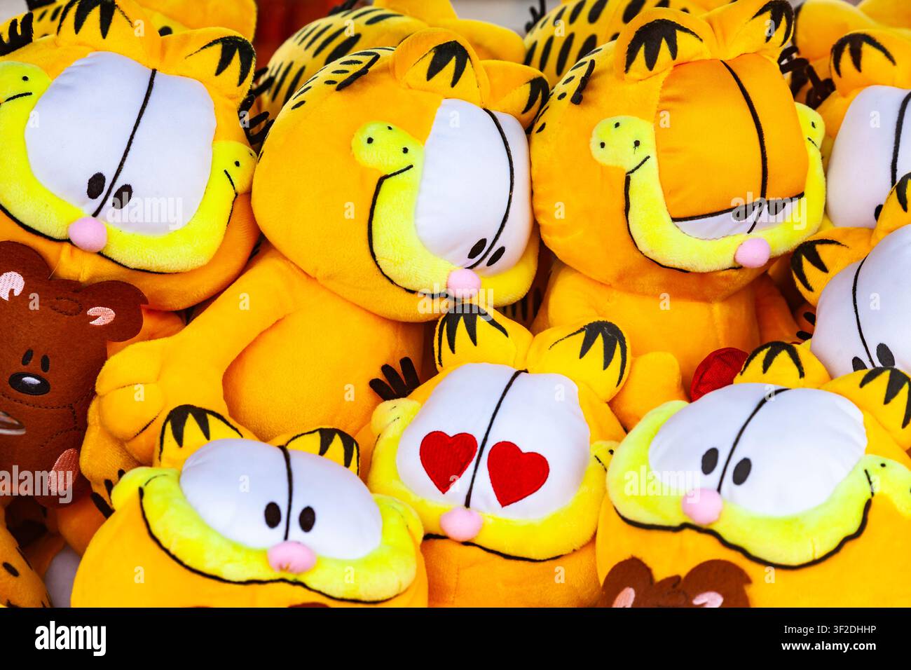 Francoforte, Germania - 15 maggio 2026: Mucchio di peluche Garfield arancioni con diverse espressioni facciali in vendita su una bancarella del mercato di strada Foto Stock