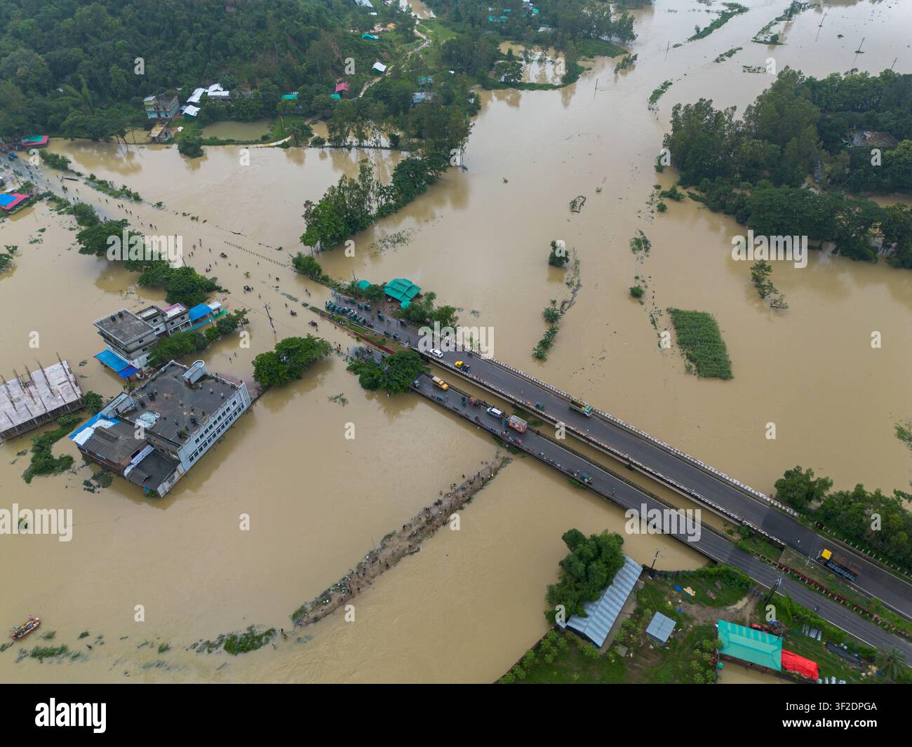 Satania, Bangladesh - 11 luglio 2026: Veduta aerea dell'autostrada Chittagong-Bandarbān sommersa dalle acque alluvionali, con veicoli che attraversano il ponte e Foto Stock