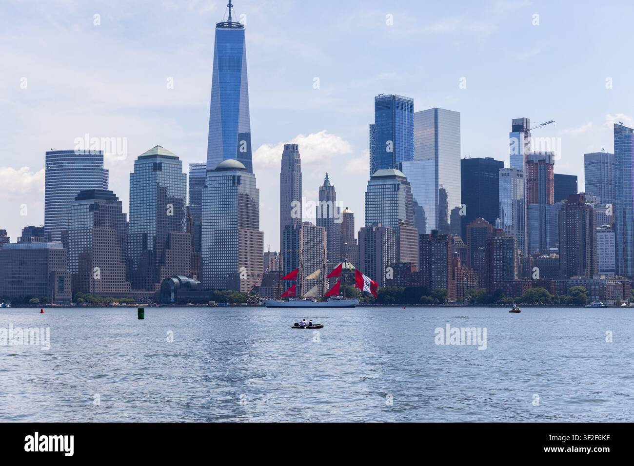 Jersey City, Stati Uniti - 04 luglio 2026: Vista del Liberty State Park con lo skyline di Manhattan e una nave a vela sull'Hudson River sotto un cielo sereno Foto Stock