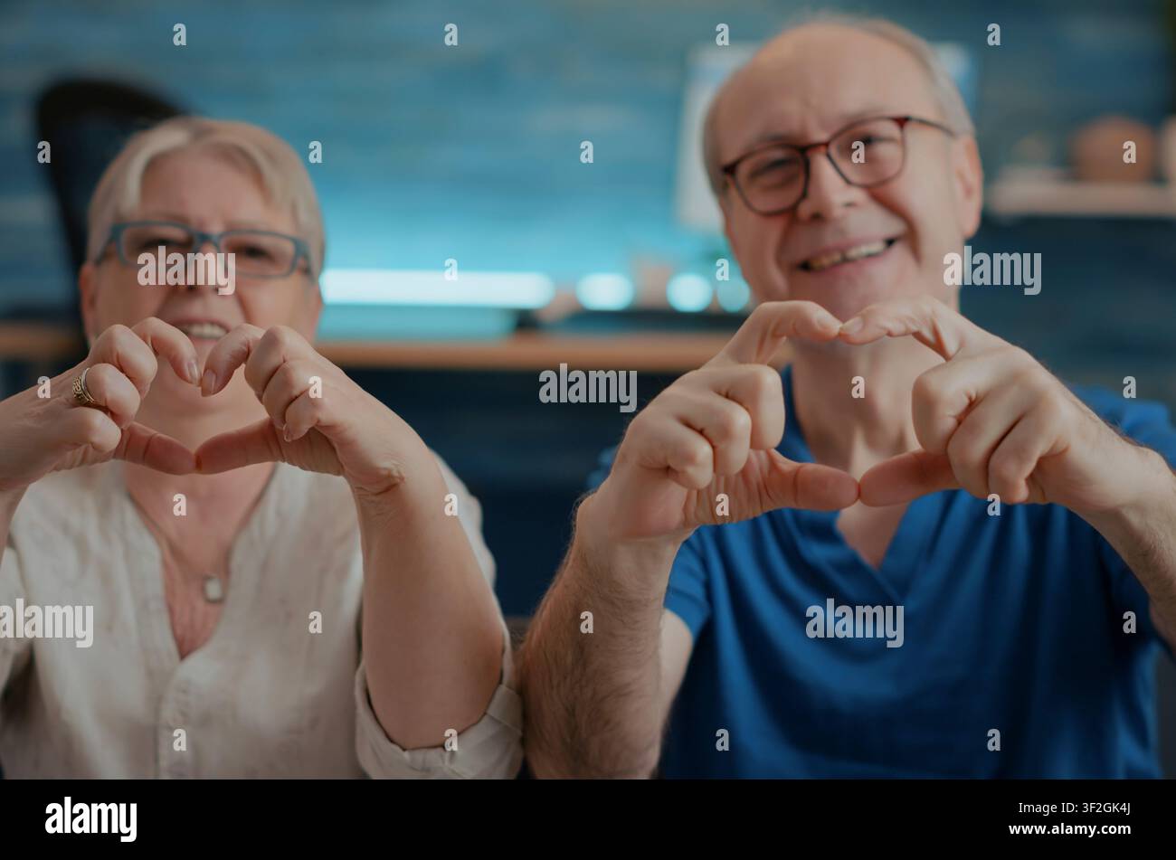 Nonni che formano una forma a cuore con le dita, nonni sposati formano una forma a cuore con le dita, esprimendo affetto, amore e devozione in un ritratto caldo. Foto Stock