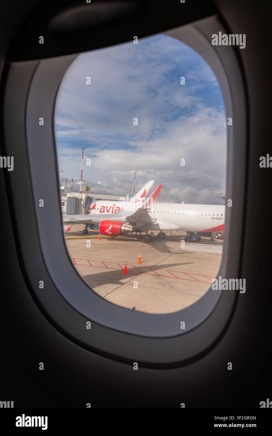 Bucaramanga, Colombia – 30 maggio 2026: vista dal finestrino di un passeggero dell’aereo che mostra un jet commerciale al gate di imbarco sulla pista, pronto per la partenza Foto Stock