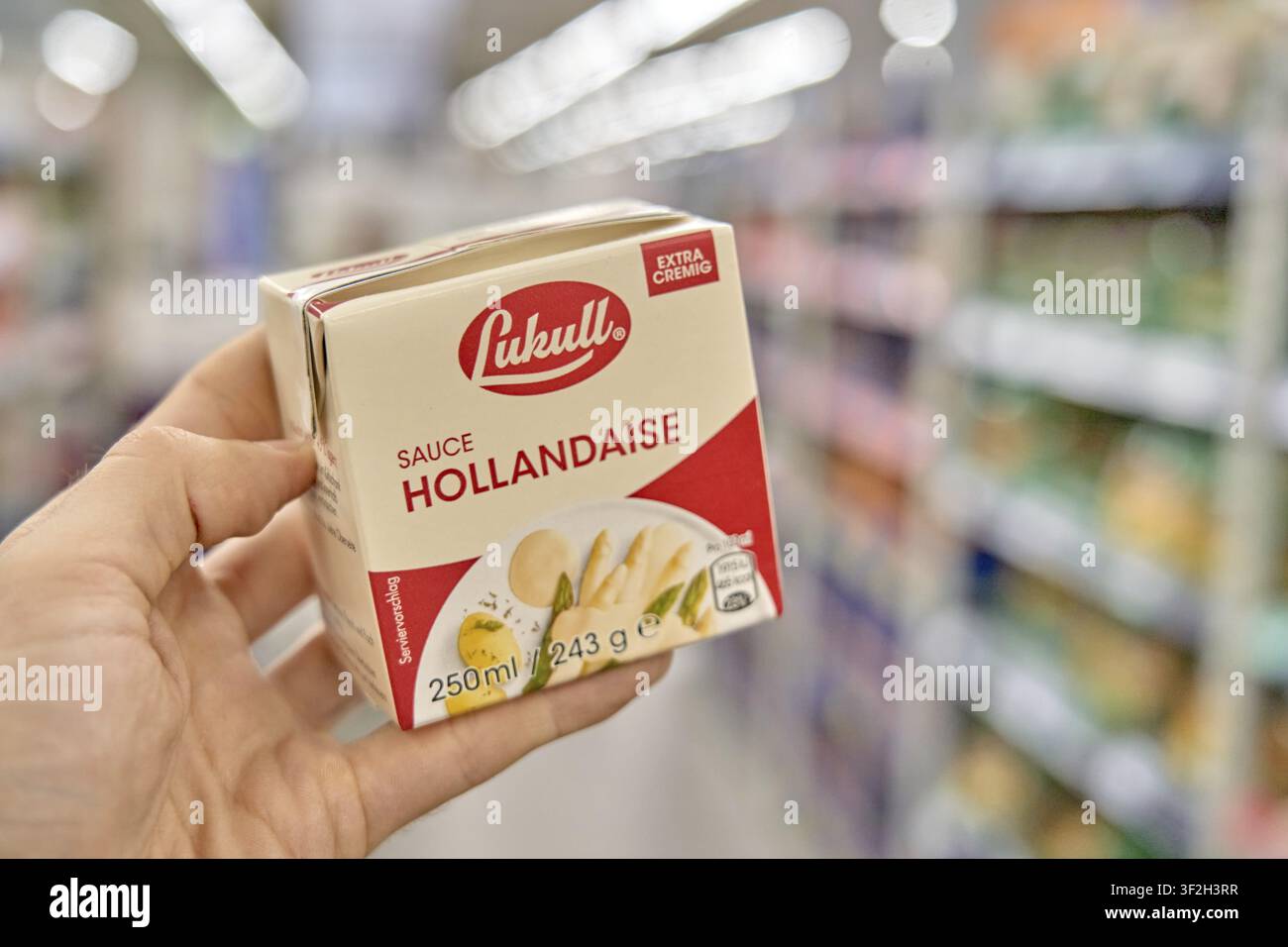 Salsa olandese Lukull, mano che presenta la salsa olandese al supermercato, sfondo sfocato, salsa, prodotto, supermercato, Kaufland, Germania Foto Stock
