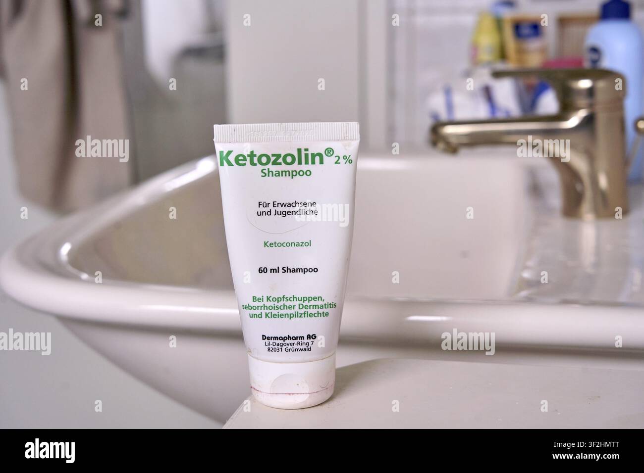 Tubo di shampoo Ketozolina sul bordo del lavandino in bagno, combatte la forfora, shampoo Ketozolina per dermatite seborroica e micosi da lievito Foto Stock