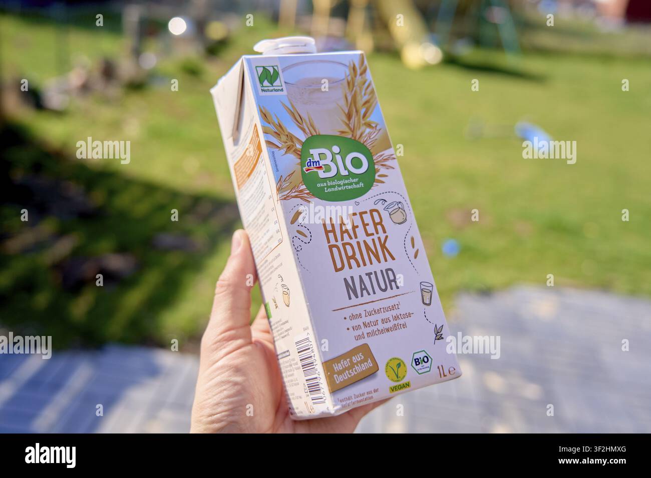 Confezione di bevanda d’avena biologica su uno sfondo sfocato all’aperto, acquistata da dm, bevanda d’avena naturale, sigillo Bioland, latte vegano, latte di cereali in confezione Tetra Foto Stock