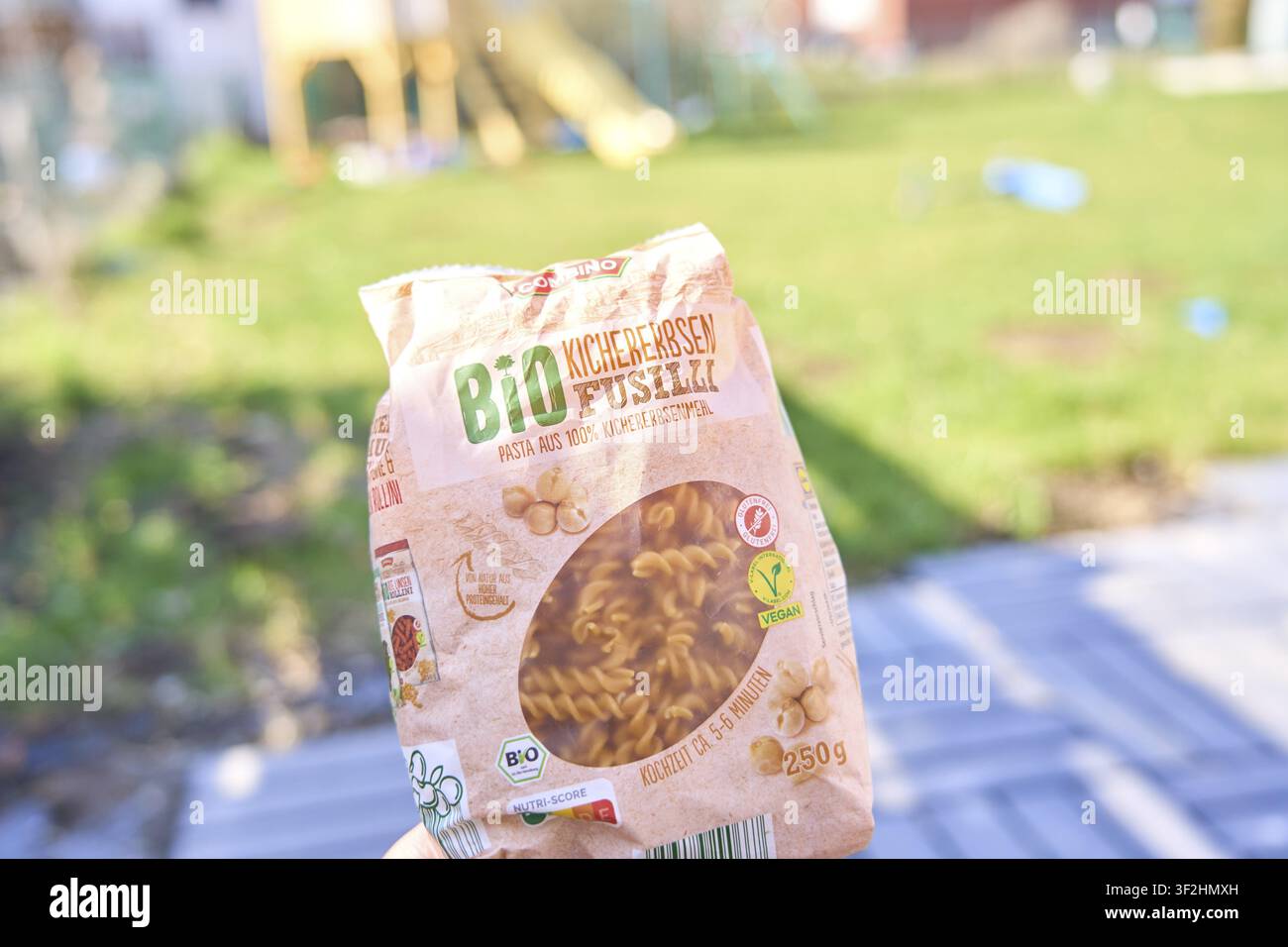 Confezione di fusilli ai ceci biologici all'aperto su uno sfondo sfocato, 250 grammi, confezionato in plastica Foto Stock