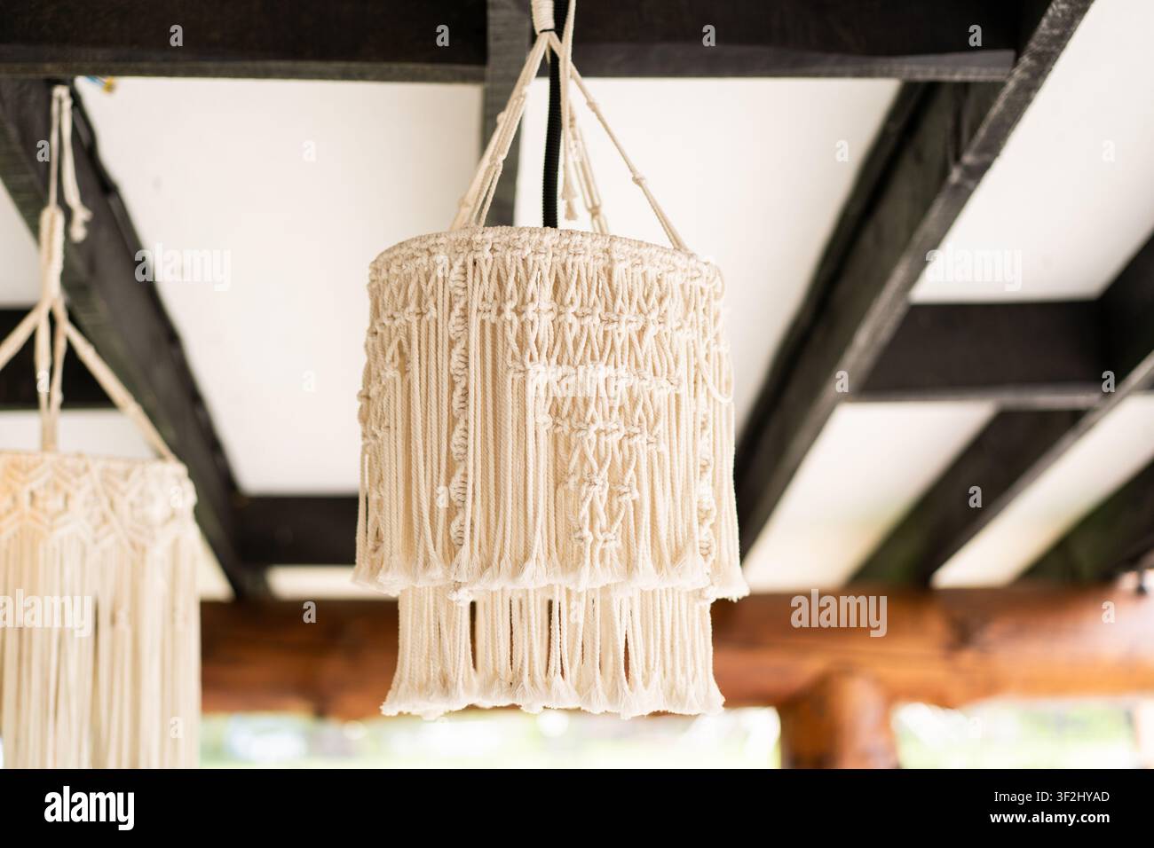 Lampada a sospensione Macrame realizzata a mano in un accogliente interno rustico Foto Stock