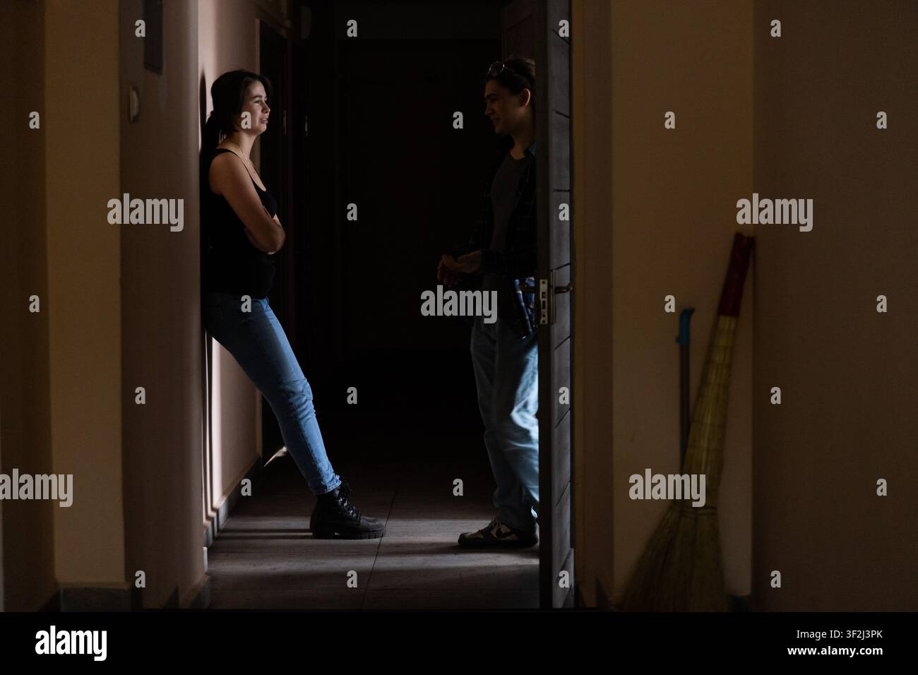 Silhouette di studenti che conversano in un corridoio buio Foto Stock
