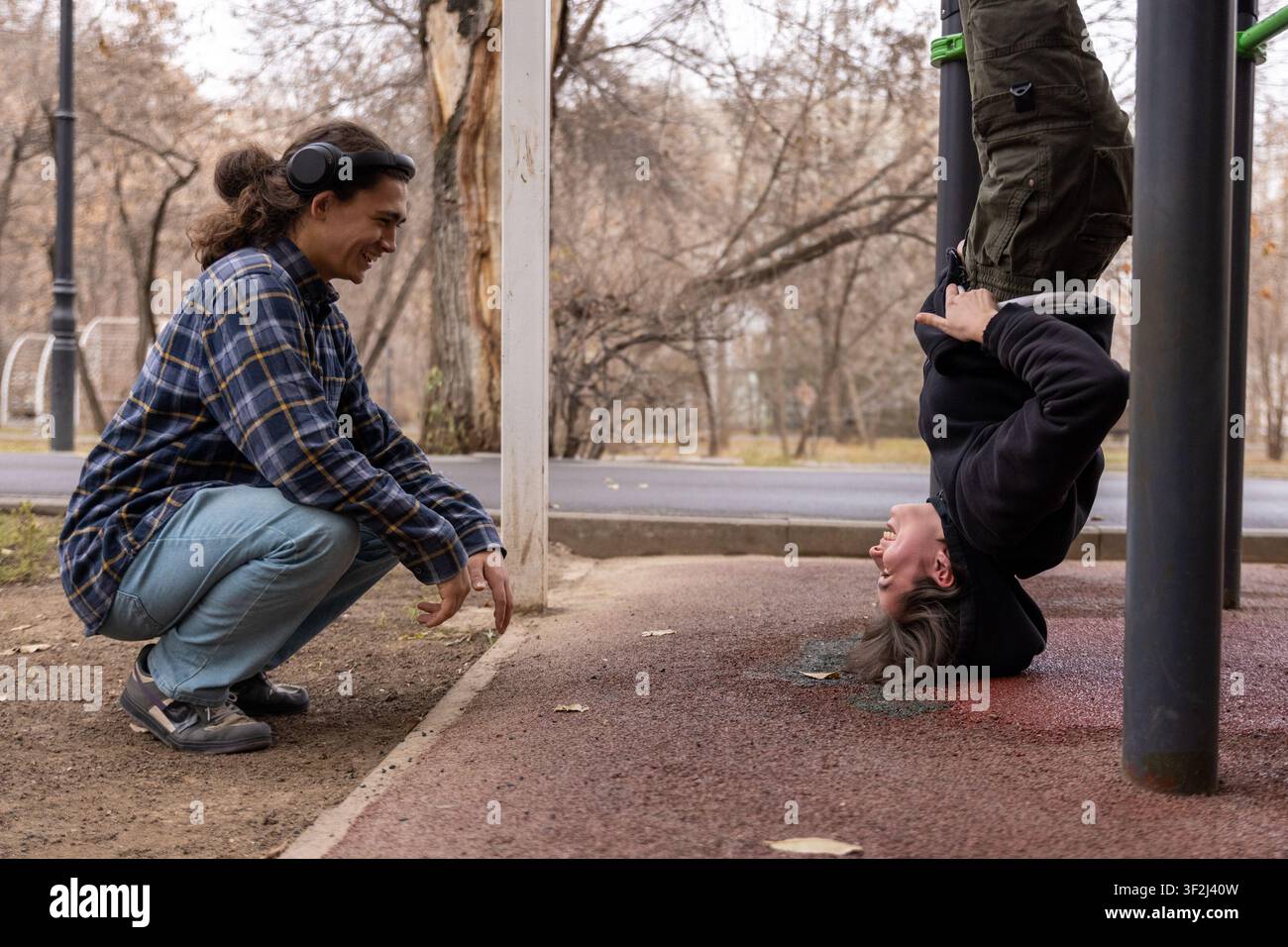 Giovane donna che fa una verticale al parco Foto Stock
