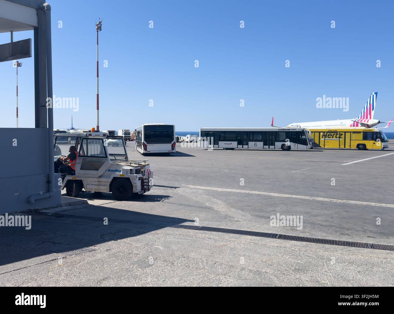Pista dell'aeroporto con veicoli di servizio a terra, navette e aereo. Foto Stock