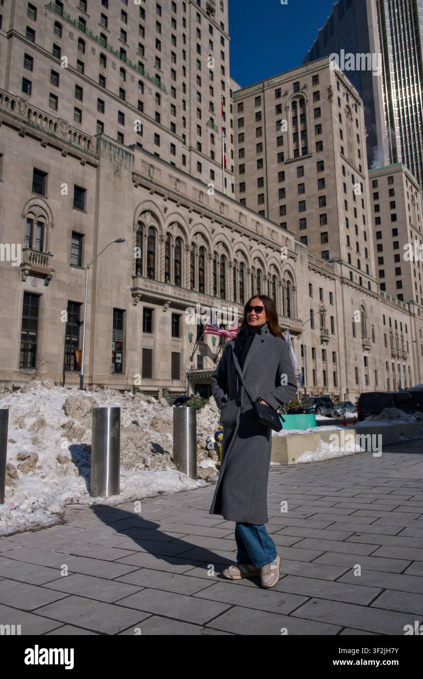 Donna passa davanti a un edificio storico a Toronto, Canada, in inverno Foto Stock