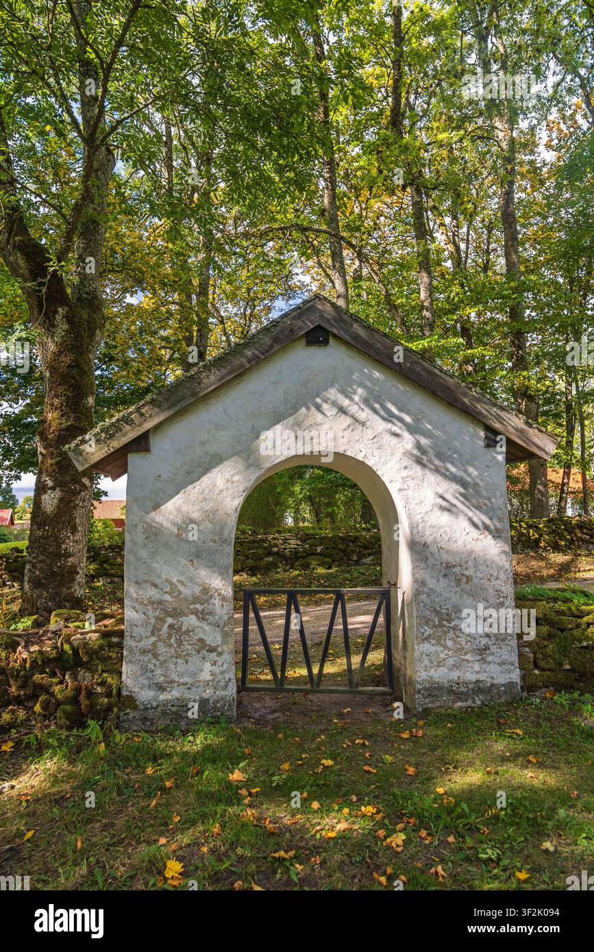 Porta della chiesa vicino a una strada in una foresta Foto Stock