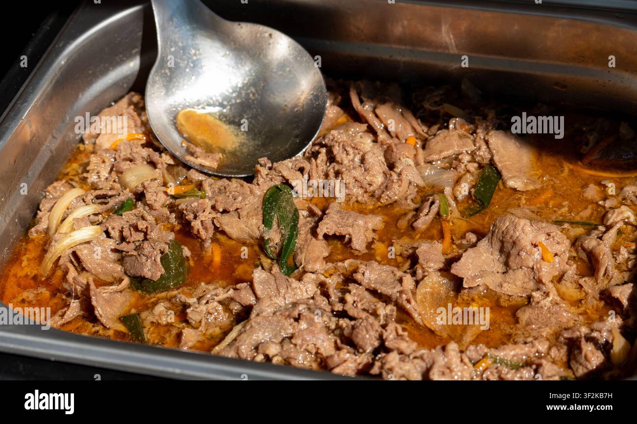 Sfondo strutturato di bistecca coreana bulgogi in una teglia da portata. Carne piccante in primo piano con verdure con messa a fuoco selettiva in un caffè di strada in una giornata soleggiata Foto Stock