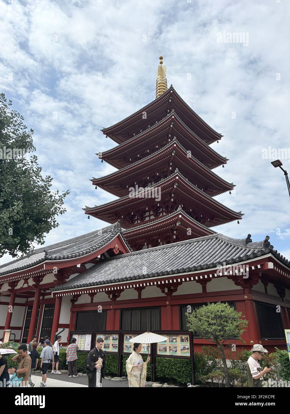 14 agosto 2025, Taito, Tokyo, Giappone – Vista a bassa angolazione dell’iconica pagoda a cinque piani del tempio buddista Senso-ji ad Asakusa, con turisti e un cielo drammaticamente nuvoloso. Foto Stock