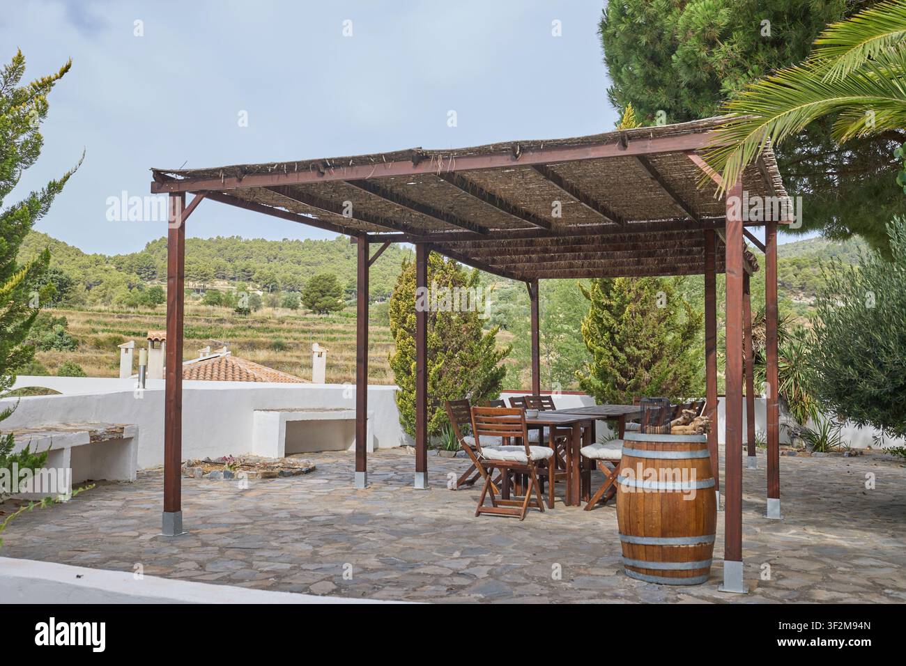 Pergola rustica con area pranzo in un ritiro di campagna mediterraneo. Foto Stock