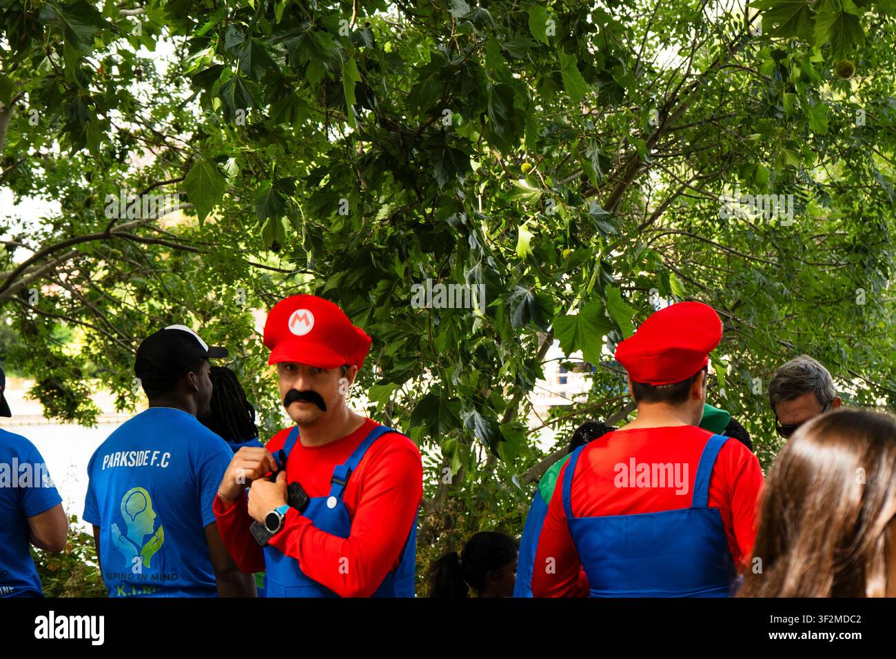 Partecipanti al festival vestiti con costumi di carnevale di Super Mario all'aperto. Foto Stock