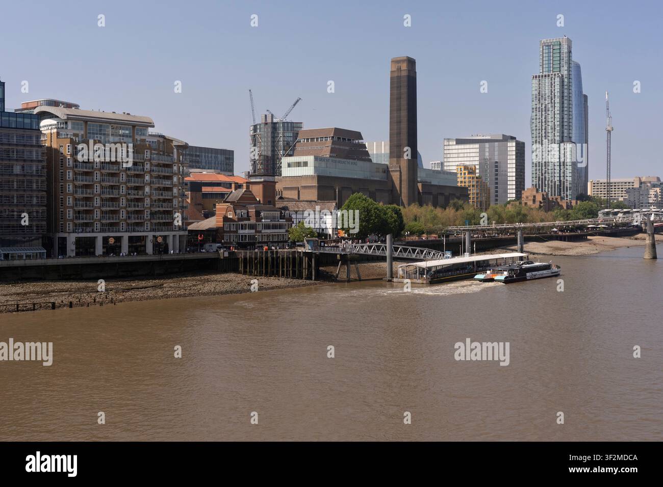 Un Uber Boat arriva al Bankside Pier sul Tamigi, con il Tate Modern che si erge alto nel cuore di South Bank a Londra. Foto Stock