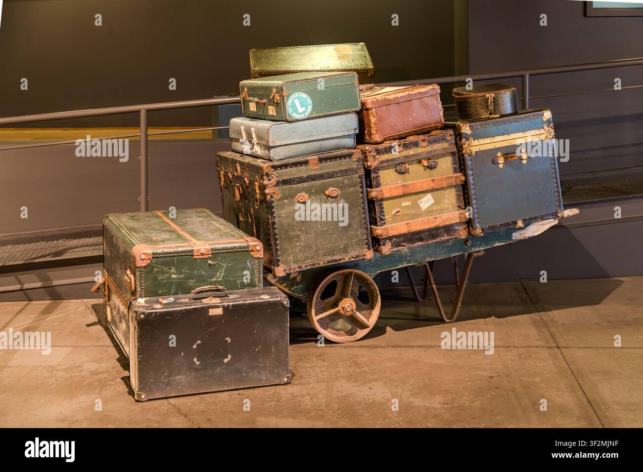 Vecchie valigie d'oltremare e bauli da viaggio su un carrello bagagli storico al Museo canadese dell'immigrazione al Pier 21 di Halifax, Nuova Scozia, Canada. Tra il 1928 e il 1971, circa un milione di immigrati sono arrivati in Canada attraverso il porto del Pier 21. Halifax, Nuova Scozia, Canada Foto Stock