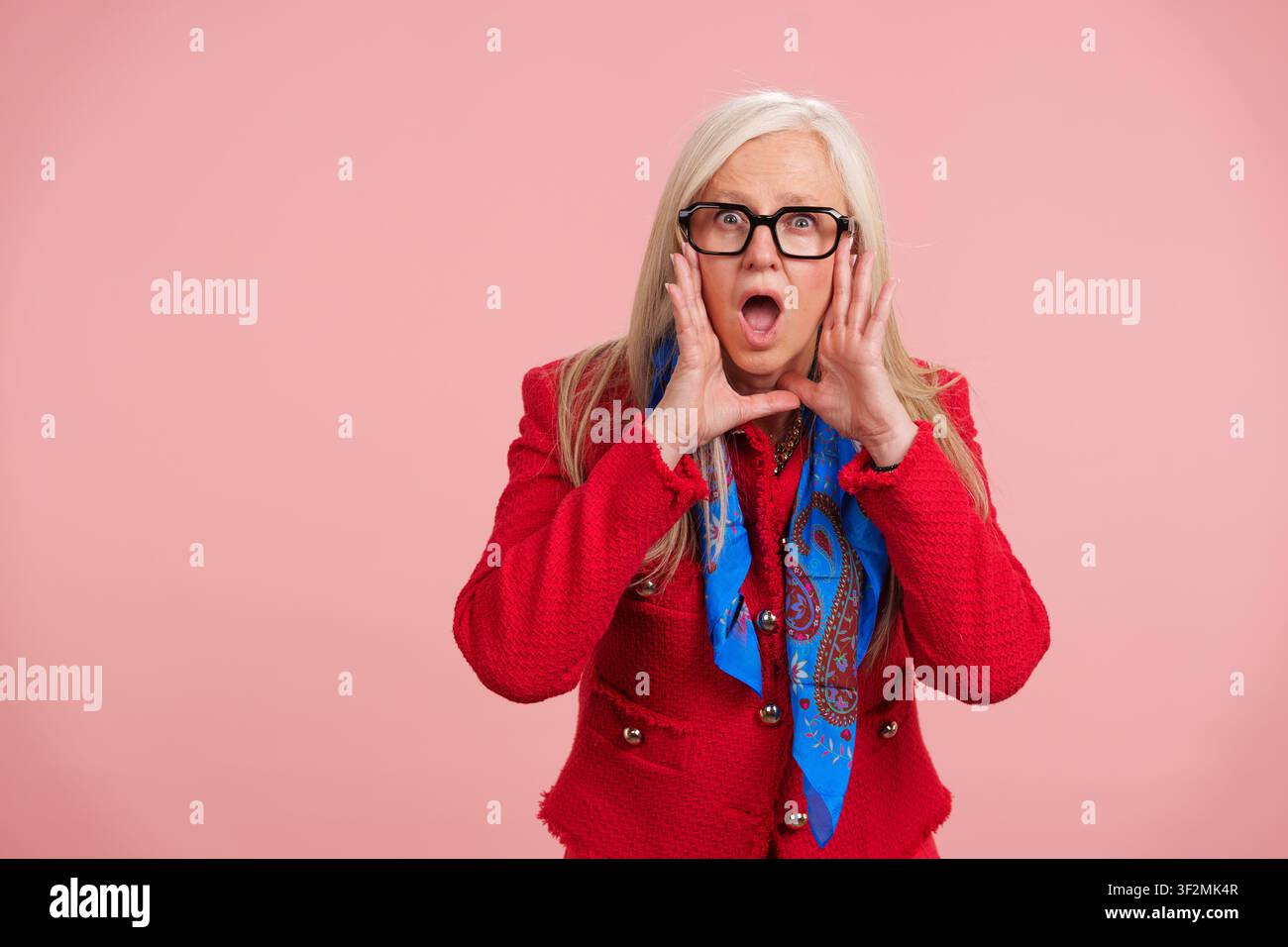 Anziana che grida notizie entusiasmanti con le mani a forma di bocca Foto Stock