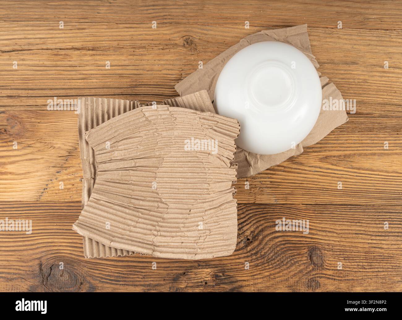 Texture di imballaggio in carta ecologica, materiale da imballaggio in cartone biodegradabile accartocciato, carta morbida riciclata ecologica, ciotola da imballaggio amichevole su sfondo di legno Foto Stock