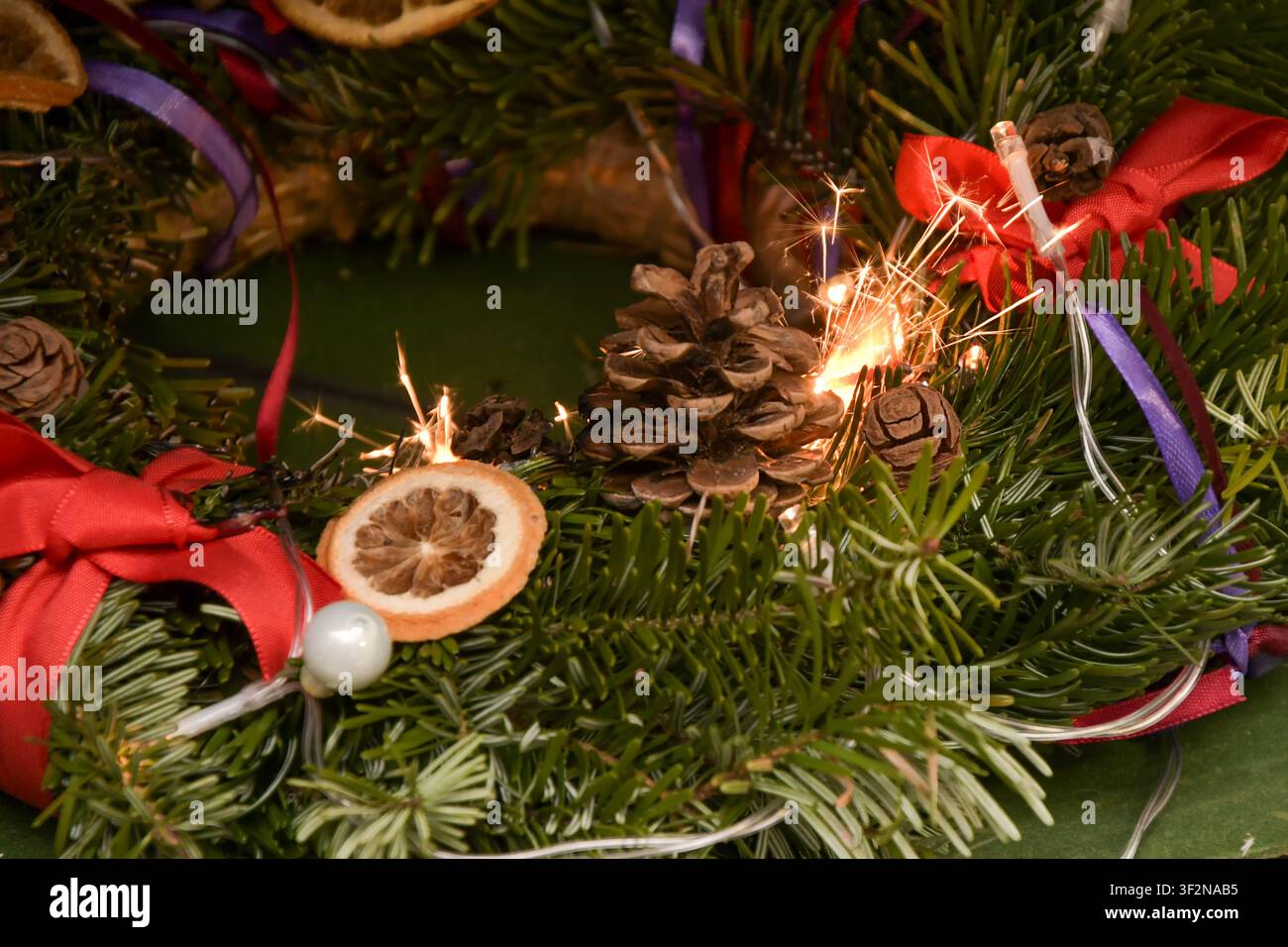 Le scintille di un fuochino accendono una ghirlanda natalizia sempreverde, creando un serio rischio di incendio interno Foto Stock