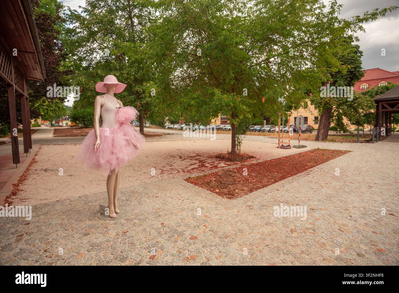 Un manichino femminile rosa in gonna in un parco cittadino utilizzato come pubblicità esterna per un negozio di abbigliamento Foto Stock