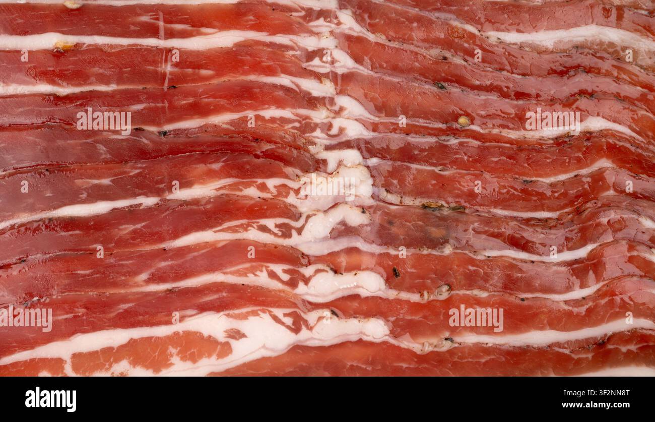 Sfondo macro di maiale carbonara affumicato, fette di pancetta affumicata cruda in primo piano, fette dettagliate di brisket striato, motivo di pancetta fresca tagliata sottile Foto Stock