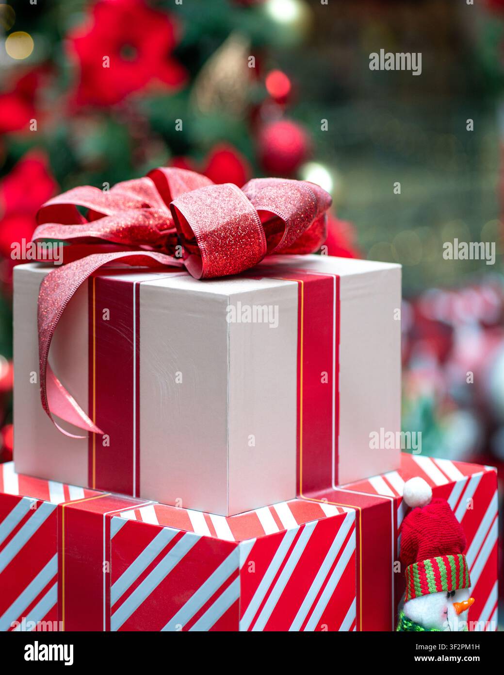 Regali di Natale in scatola, incartati e legati con un nastro rosso. Concetto di stagione delle festività. Foto Stock
